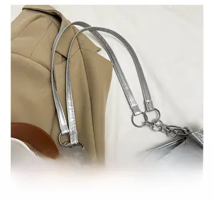 Detailed shot of the silver metallic shoulder bag showing the adjustable chain strap