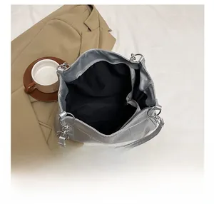 Macro view showing the spacious interior and silver metallic hardware of the tote bag