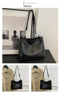Detail of minimalist black leather tote bag with patchwork texture and silver chain strap