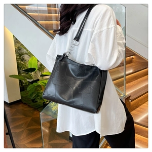 Detail of vintage black tote bag with geometric stitching and silver link rings