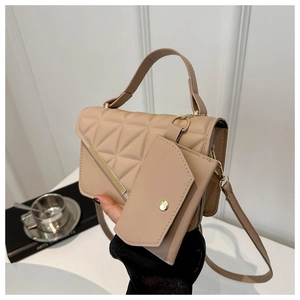 Close-up of beige quilted geometric handbag with gold hardware and small pouch