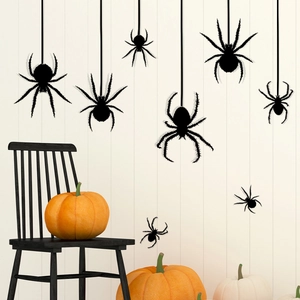 Black Halloween spider wall stickers shown on white wooden background with pumpkins