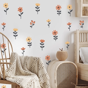 Floral wall decals in warm orange and ginger yellow on white wall above wooden furniture