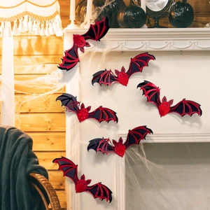 Close-up of 3D laser-cut glitter bats on a white fireplace with Halloween decor