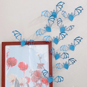 Detailed view of blue glitter bat wall stickers with laser-cut hollow wing design
