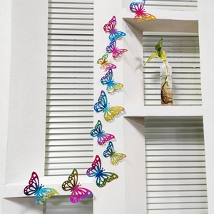 Macro detail of 3D rainbow gradient butterfly wall stickers with glitter texture on a wall
