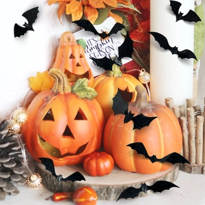 Close-up of black 3D glitter bat wall stickers with festive pumpkins and candles