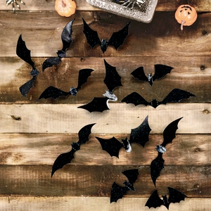 Macro detail of 3D glitter bat wall stickers on rustic wood for Halloween decor