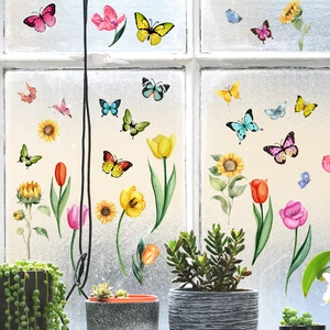 Vue détaillée d'autocollants papillons et fleurs colorés sur une vitre en verre dépoli