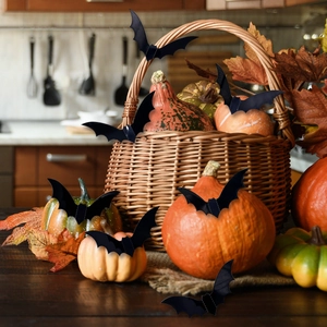 3D black bat decorations of various sizes placed in a rustic pumpkin harvest basket