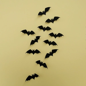 Set of 12 3D black bat wall stickers for Halloween home decor on a yellow background