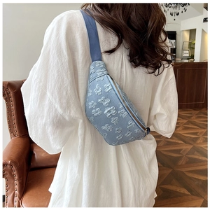 Detail of light blue floral jacquard chest bag with wide strap and golden zipper