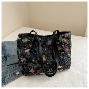 Detail of colorful butterfly embroidery and logo tag on a large capacity tote bag