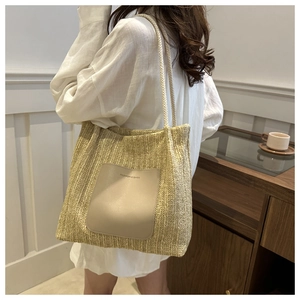 Straw woven tote bag with leather patch on white shirt model in minimalist interior