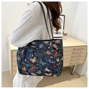 Detail of butterfly jacquard fabric on a large tote bag with a leather strap