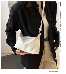 Détail de la texture d'un sac à bandoulière beige avec sangle sur un mannequin