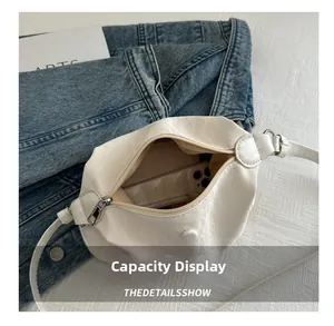 Vue détaillée montrant la grande capacité du sac plissé blanc avec un smartphone