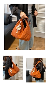 Détail du sac cabas orange en toile avec texture plissée et joli pendentif en bouteille
