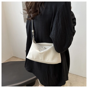 Détail du sac à bandoulière demi-lune blanc élégant avec fermeture éclair et sangle