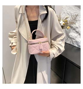 Pink quilted bucket bag with chain strap shown on a model for an elegant lifestyle look