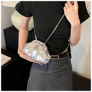 Détail d'un sac à plis métallisé argenté avec finition miroir et bandoulière fine