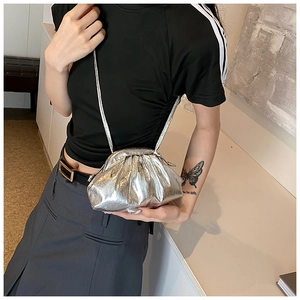 Détail d'un sac plissé argenté à effet métallisé avec une fine bandoulière élégante