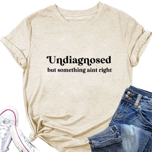 Detailed flat lay of beige crew neck t-shirt with black Undiagnosed slogan and denim shorts