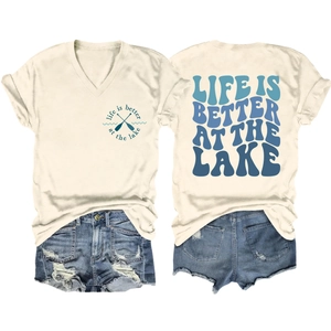 Flat lay of off-white V-neck T-shirt with 'Life is Better at the Lake' print and denim shorts