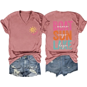 Flat lay of pink V-neck t-shirt with boat sun lake prints and ripped denim shorts
