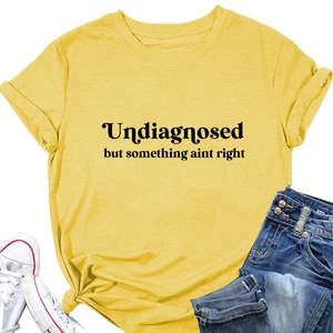 Flat lay of yellow cotton T-shirt with 'Undiagnosed but' text, shorts and shoes