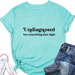 Close-up of mint green cotton t-shirt with slogan and stylish knotted hem detail