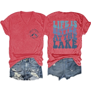 Detailed view of red V-neck T-shirt with lake graphic and distressed denim shorts