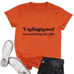 Orange crew neck t-shirt featuring black slogan print with white shoes and black shorts