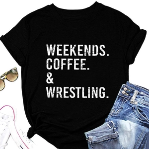 Flat lay di una T-shirt nera Weekends Coffee & Wrestling con accessori casual
