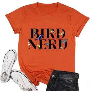 T-shirt Bird Nerd orange avec motifs d'oiseaux, short noir et baskets blanches à plat