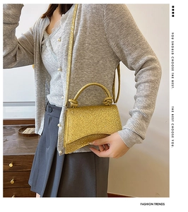 Detail of sequined gold handbag with unique curved base and stylish knotted handle