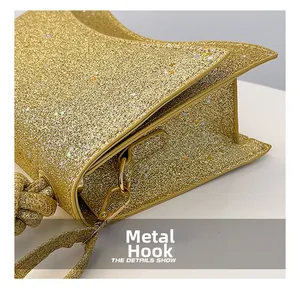 Detail of the high-gloss gold metal hook and glittery fabric texture on this handbag