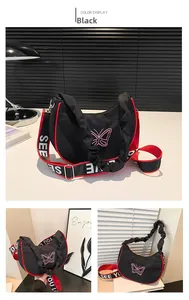 Détail du sac demi-lune noir avec broderie papillon et bordures contrastées rouges