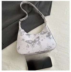 Detailed top view of a bow hobo bag with butterfly prints and mobile phone for size scale