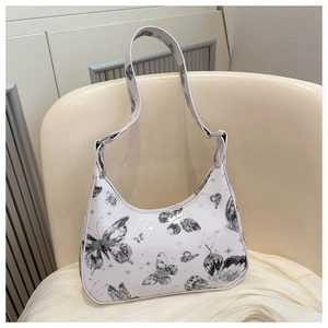 Close-up of white Y2K hobo bag with butterfly patterns on a cream chair