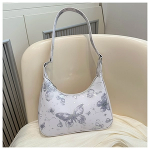 Detail of white PU leather underarm bag with silver butterfly and star patterns