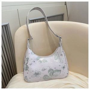 Close-up of white PU leather baguette bag featuring soft green butterfly and star prints