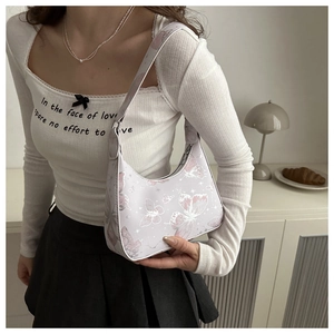 Detailed view of butterfly print shoulder bag with pastel pink PU leather texture