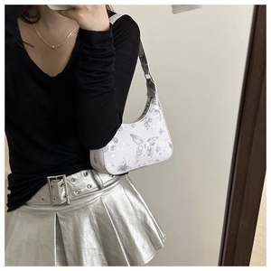 Close-up of Y2K style hobo bag with lavender butterfly and star patterns on model