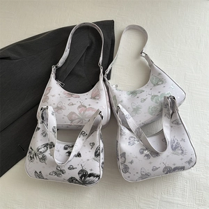 Minimalist white hobo bags with butterfly prints in a flat lay with a grey blazer