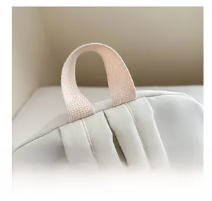 Detail of reinforced oxford cloth top handle and stitching on the white casual backpack