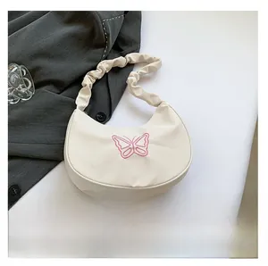 Detail of off-white pleated shoulder bag with pink butterfly embroidery and a phone for size