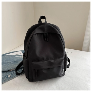 Detail of minimalist black oxford backpack side with fashion tag and water bottle pocket