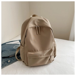 Close-up of khaki Oxford fabric backpack featuring a side label and durable nylon texture