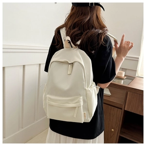 Detail of a beige minimalist backpack with yellow FASHION label and side pocket